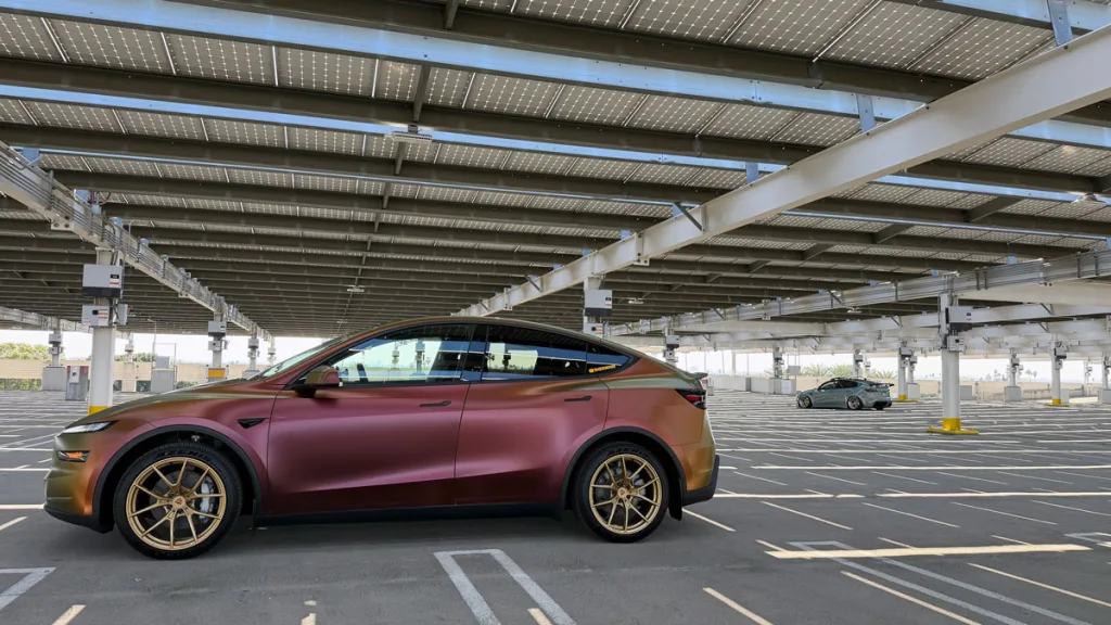 Wrapped Model Y Juniper and Model Y in the back in a parking lot