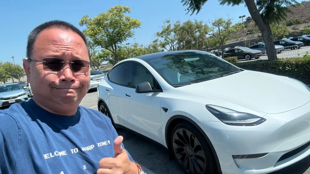 Guy thumbs up next to 2022 Model Y Performance