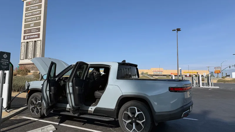 Electric truck charging at station.