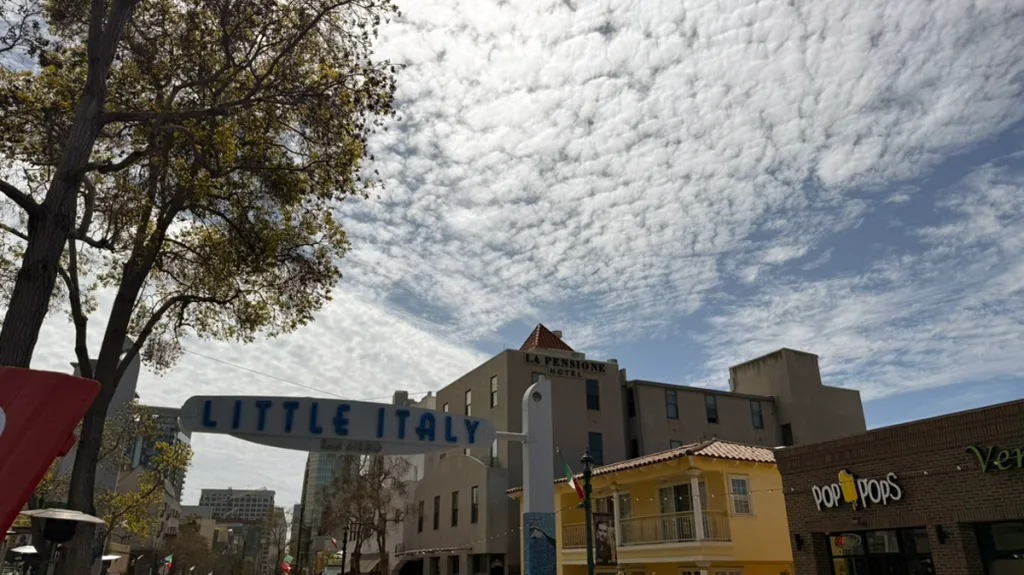 Cloudy sky over Little Italy sign